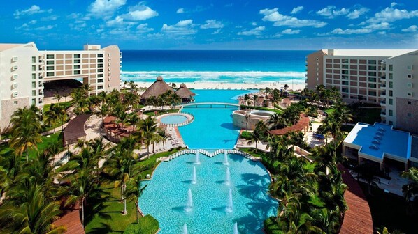 A resort with multiple swimming pools, a beach, and ocean views.