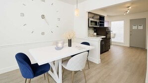 A modern kitchen with a white countertop, dark cabinets, and a built-in oven. - Royal Retreat | 2BR • 5 Min Walk to Galleria (Houston)