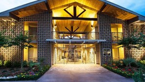 A modern building with a wooden facade, a central entrance, and a balcony. - Royal Retreat | 2BR • 5 Min Walk to Galleria (Houston)