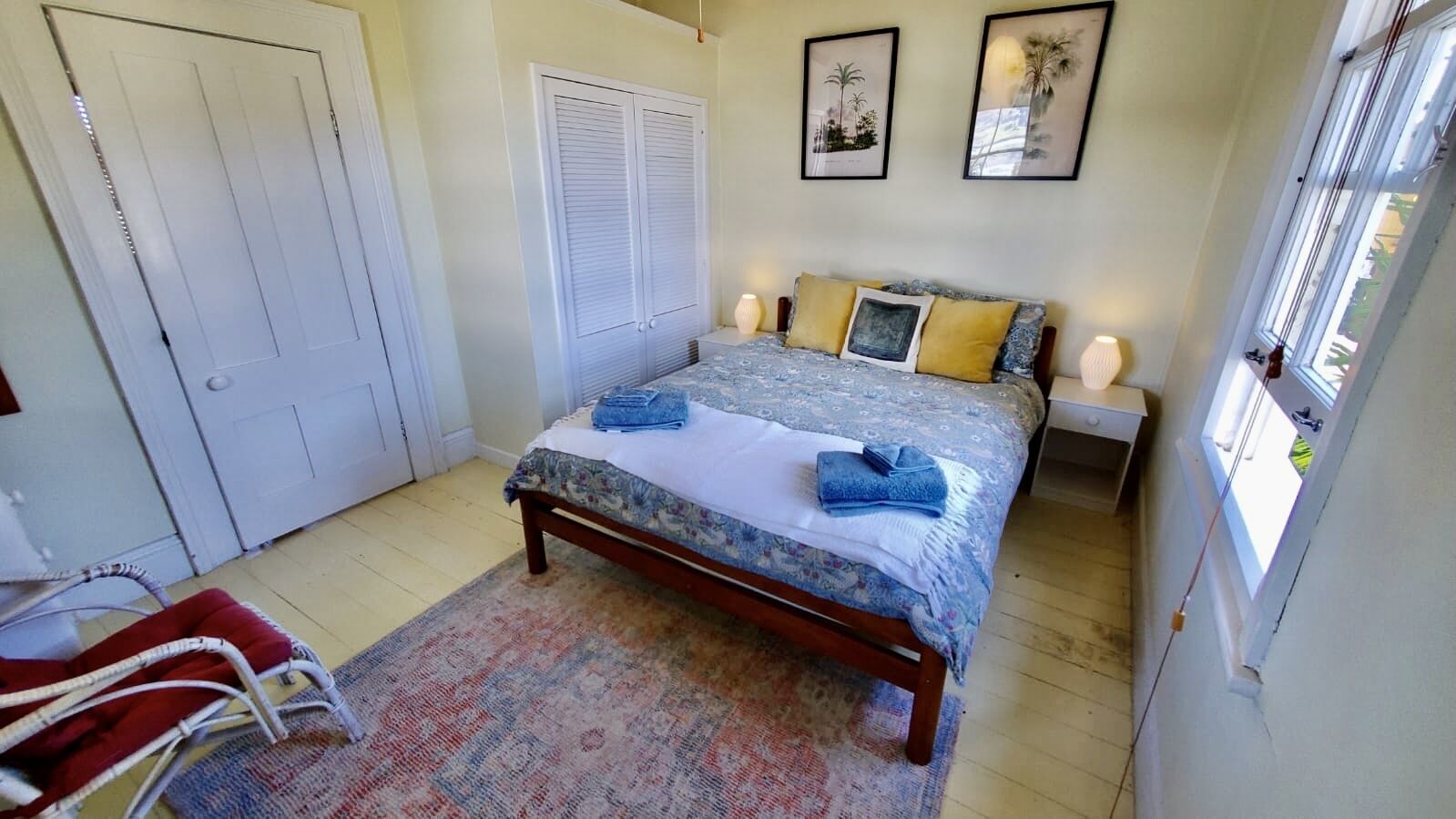 Une chambre à coucher avec un lit, une chaise, une porte et une fenêtre.