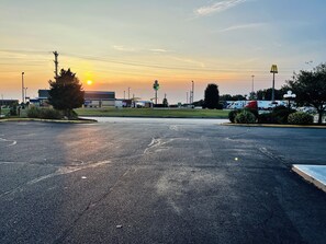 A parking lot with a McDonald's sign, a large building in the background, and a clear sky.