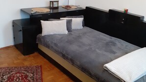 A bedroom with a bed, bedside tables, a desk, a lamp, and a rug. - 2-Bedroom Apartment in Bucharest near town center (Bucharest)