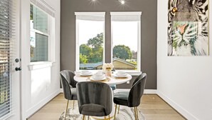A dining area with a round table set for four, black chairs, and a view through large windows. - Luxury Houston Downtown townhome Minute Maid/Toyota/ Medical center (Houston)