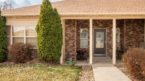 A house with a stone facade, a front porch, and a door with a decorative glass panel. - COMFY  2 bedroom 1 bath, living room, mini kitchen with 70" smart TV & Grill (Montrose)