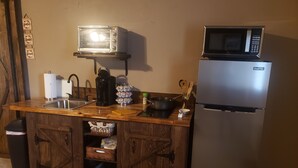 A kitchen with a wooden countertop, a sink, a toaster oven, a microwave, and a refrigerator. - COMFY  2 bedroom 1 bath, living room, mini kitchen with 70" smart TV & Grill (Montrose)