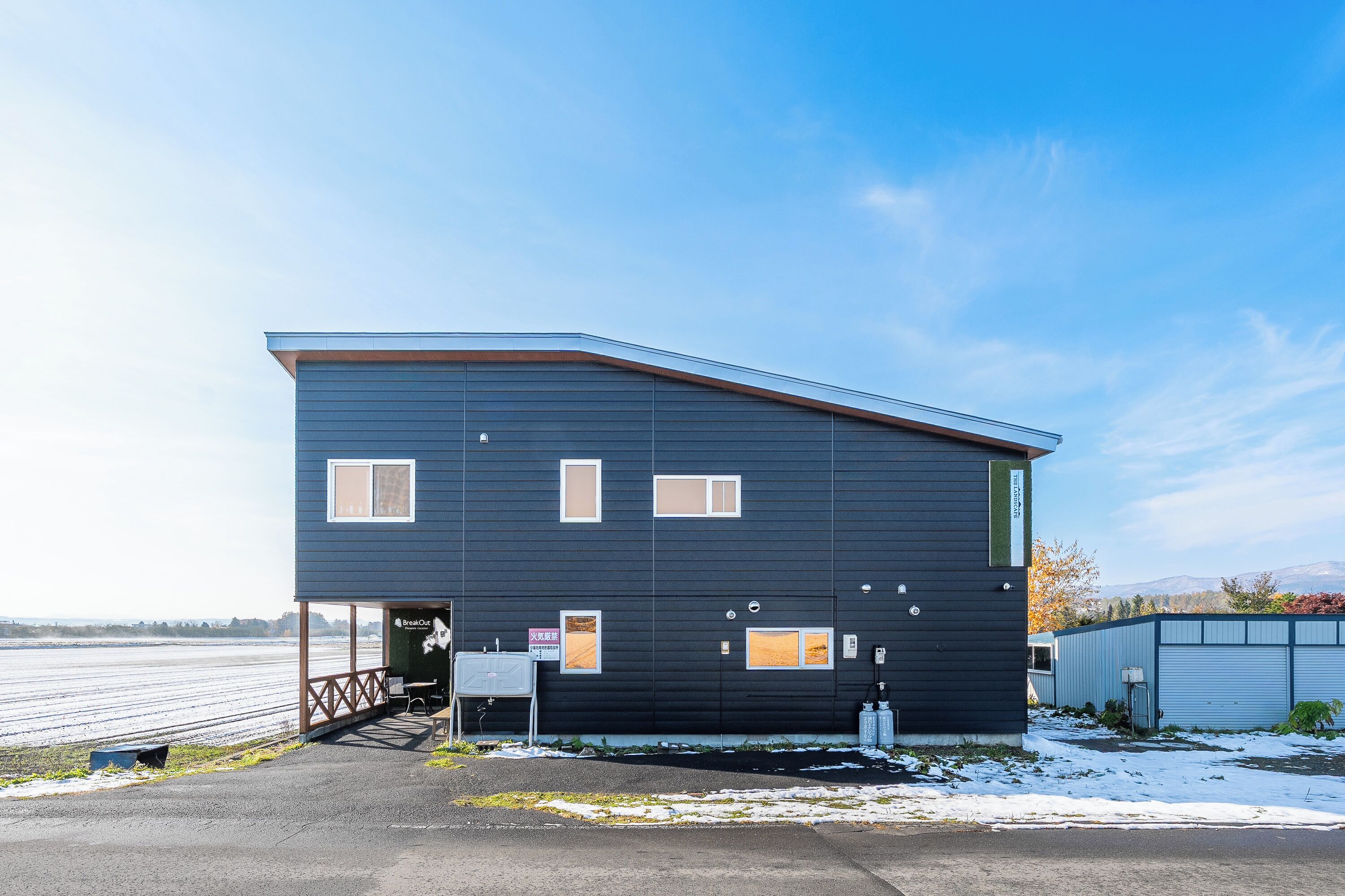 A modern two-story building with a flat roof and a covered entrance area.