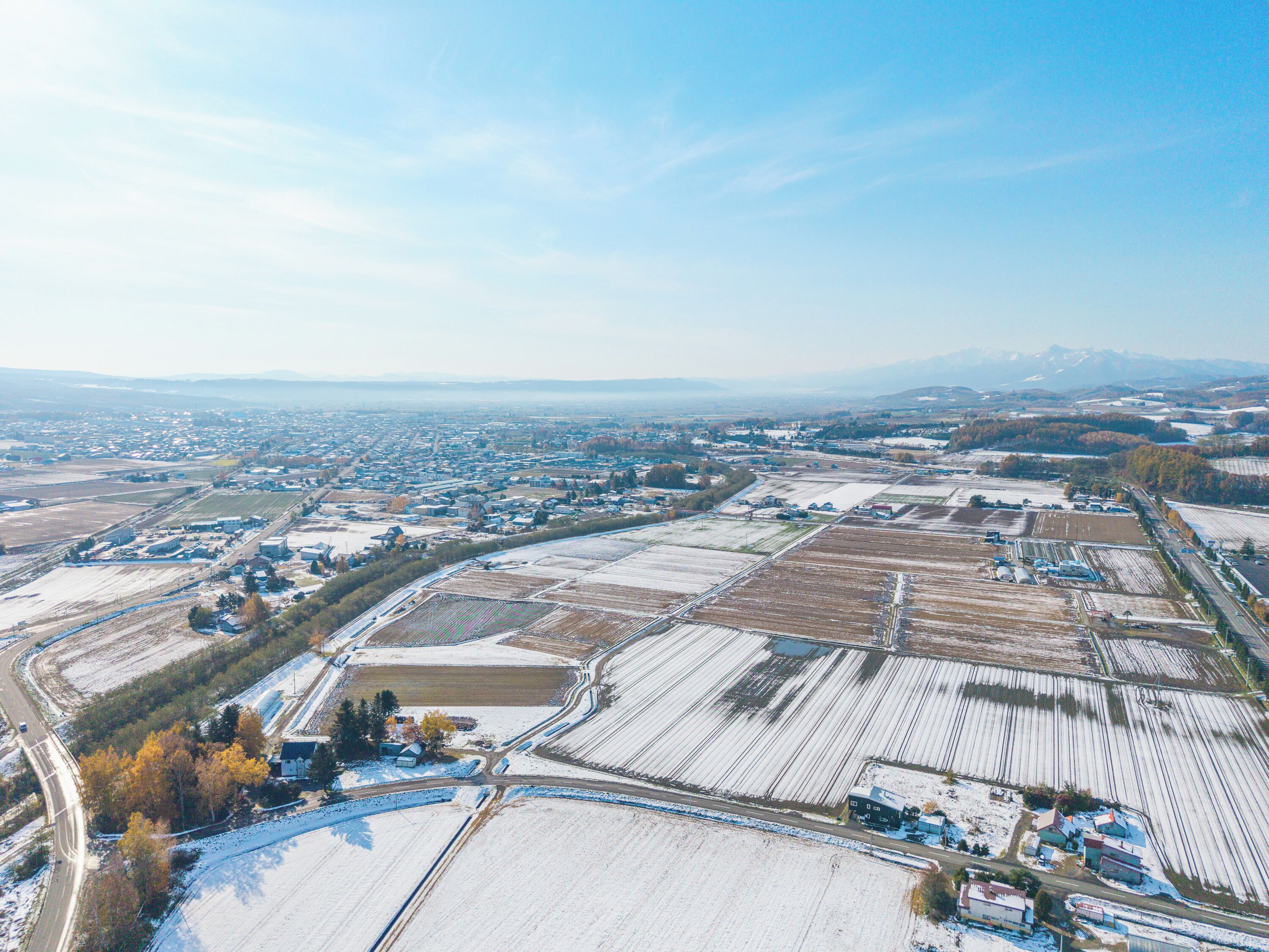 An aerial view of a rural area with fields, roads, and buildings.