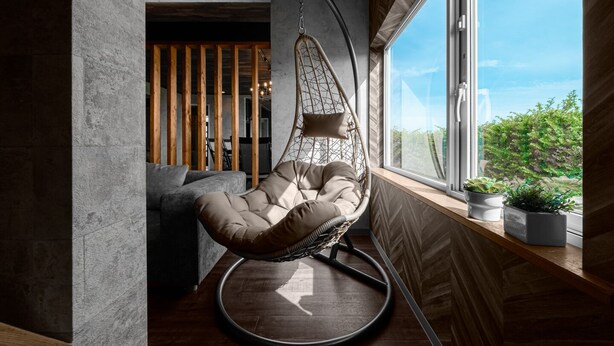 A modern room with a hanging chair by a large window, wooden slats, and potted plants. - THE LANDSCAPE (Kamifurano)