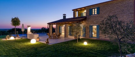 A spacious outdoor patio area with a pool, seating, and a covered section.