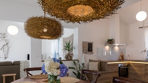 A modern kitchen with a central island, wooden chairs, and a dining table with woven placemats. - Villa Toscana by Interhome (Umag)