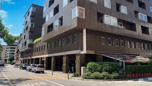 Un hotel de varios pisos con un diseño moderno, que cuenta con balcones y ventanas amplias.