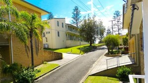 A residential street with houses, a clear sky, and greenery. - 1/6 Convent Lane (Yamba)