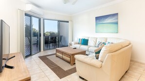 A modern living room with a sofa, coffee table, and TV. - Breakers 2/2 (Yamba)