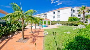 A courtyard with a pool, palm trees, and a gazebo. - Breakers 2/2 (Yamba)