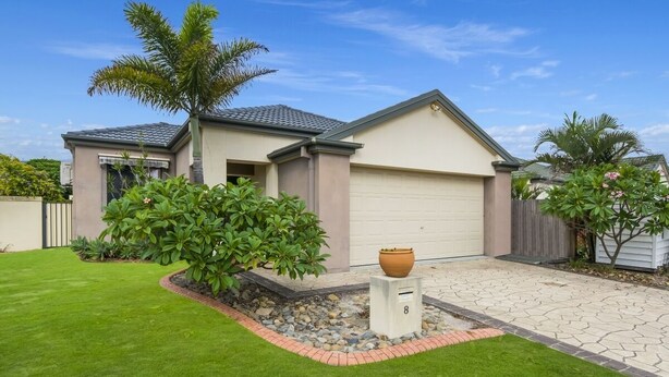 A two-story house with a garage, a well-maintained lawn, and a large planter in the front yard. - Oceania Beach Paradise (Yamba)