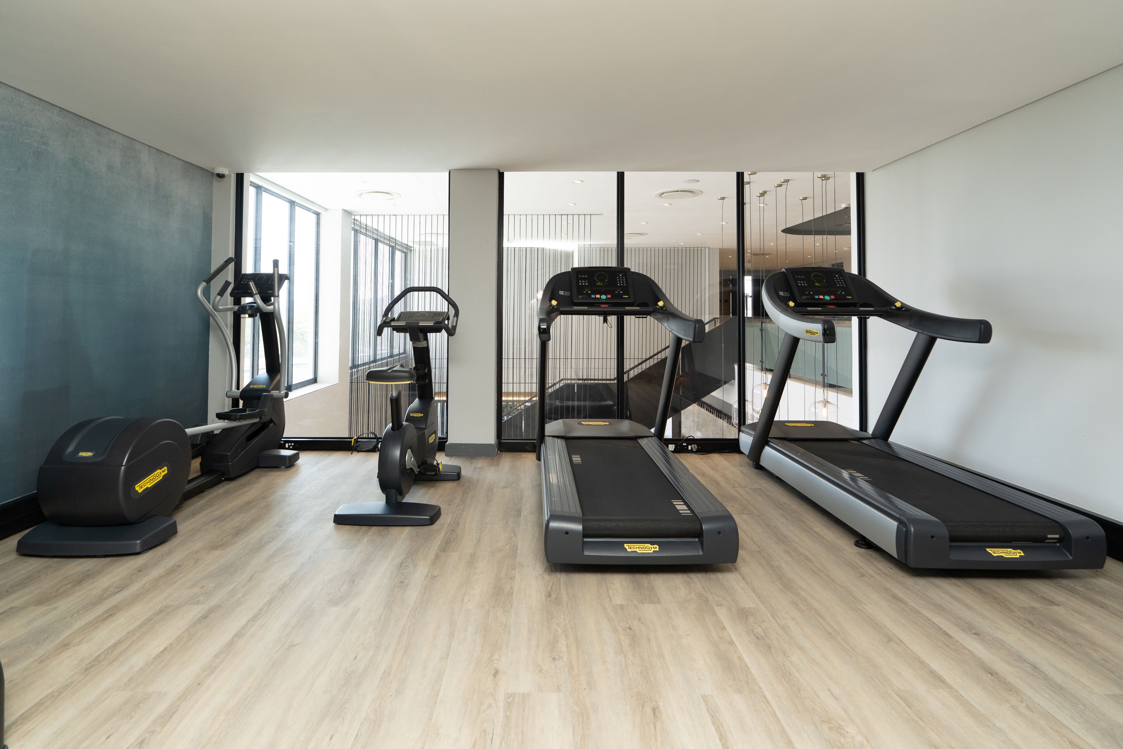 A modern gym with treadmills, an elliptical, and a stationary bike.