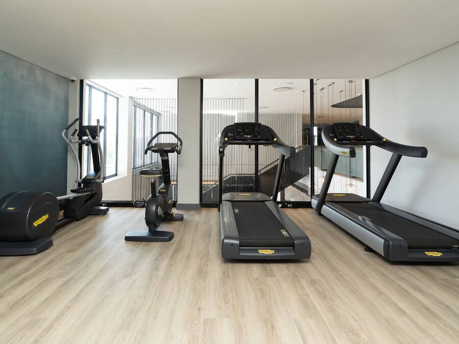 A modern gym with treadmills, an elliptical, and a stationary bike.