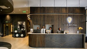 A reception desk with a modern design, featuring a logo and name 'The Capital Mbombela'. - The Capital Mbombela (Mbombela)