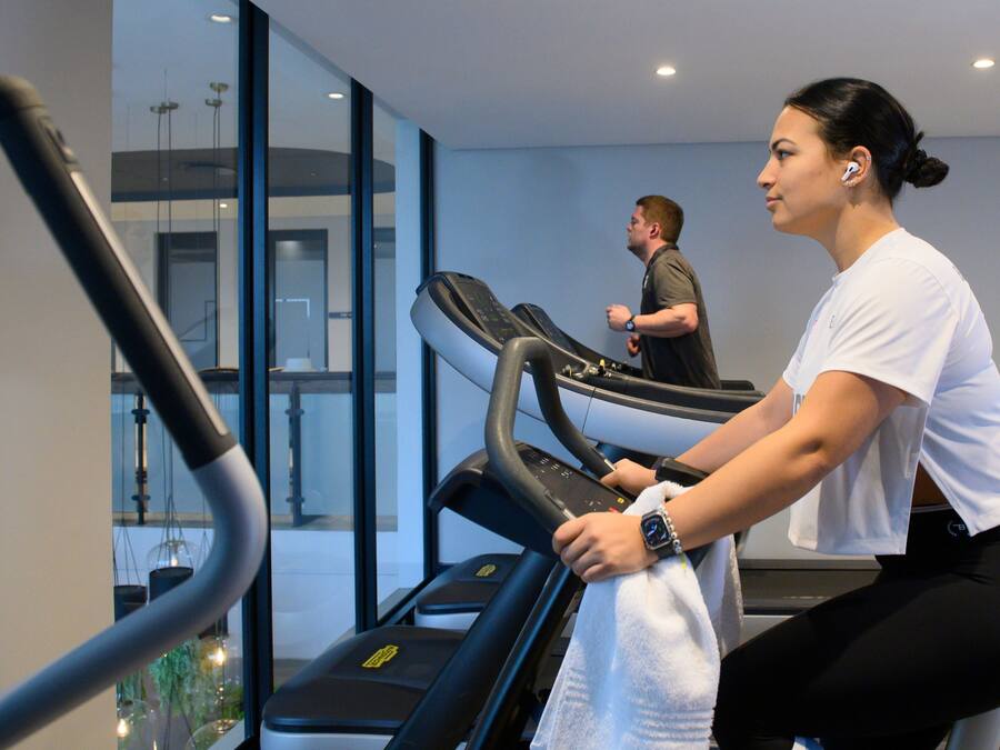 A gym with treadmills and a glass wall.