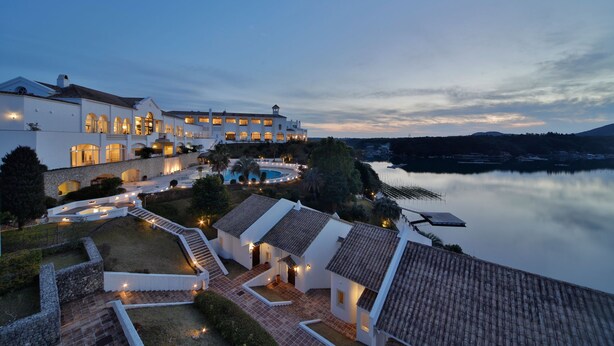 A large, multi-story building with a pool and a view of a calm lake at dusk. - Miyako Resort Shima Bayside Terrace (Shima)
