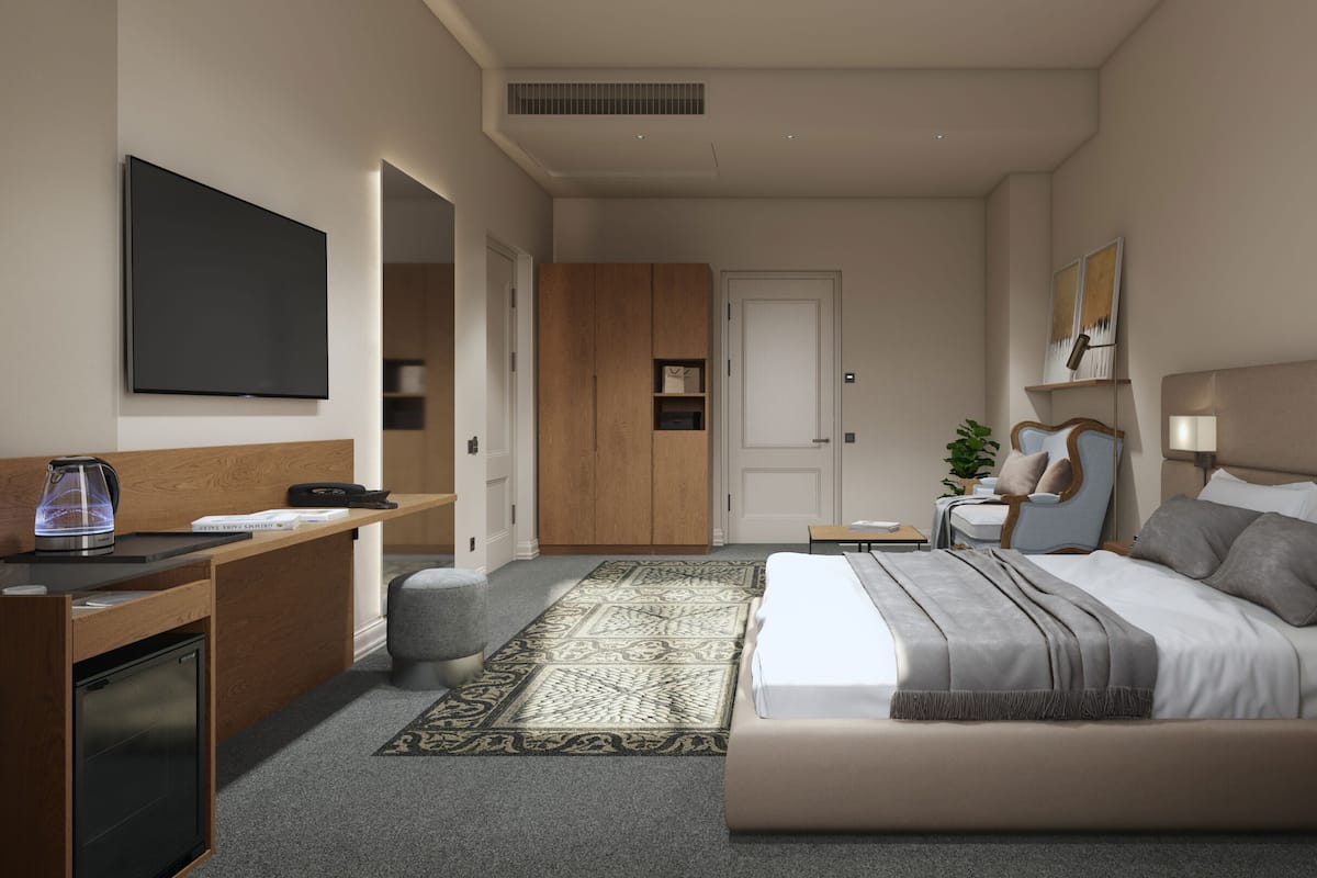 A modern hotel room with a bed, desk, and seating area.
