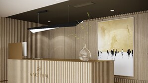 A reception desk with a modern design, a wooden panel wall, and a large abstract painting. - Maestral (Lviv)
