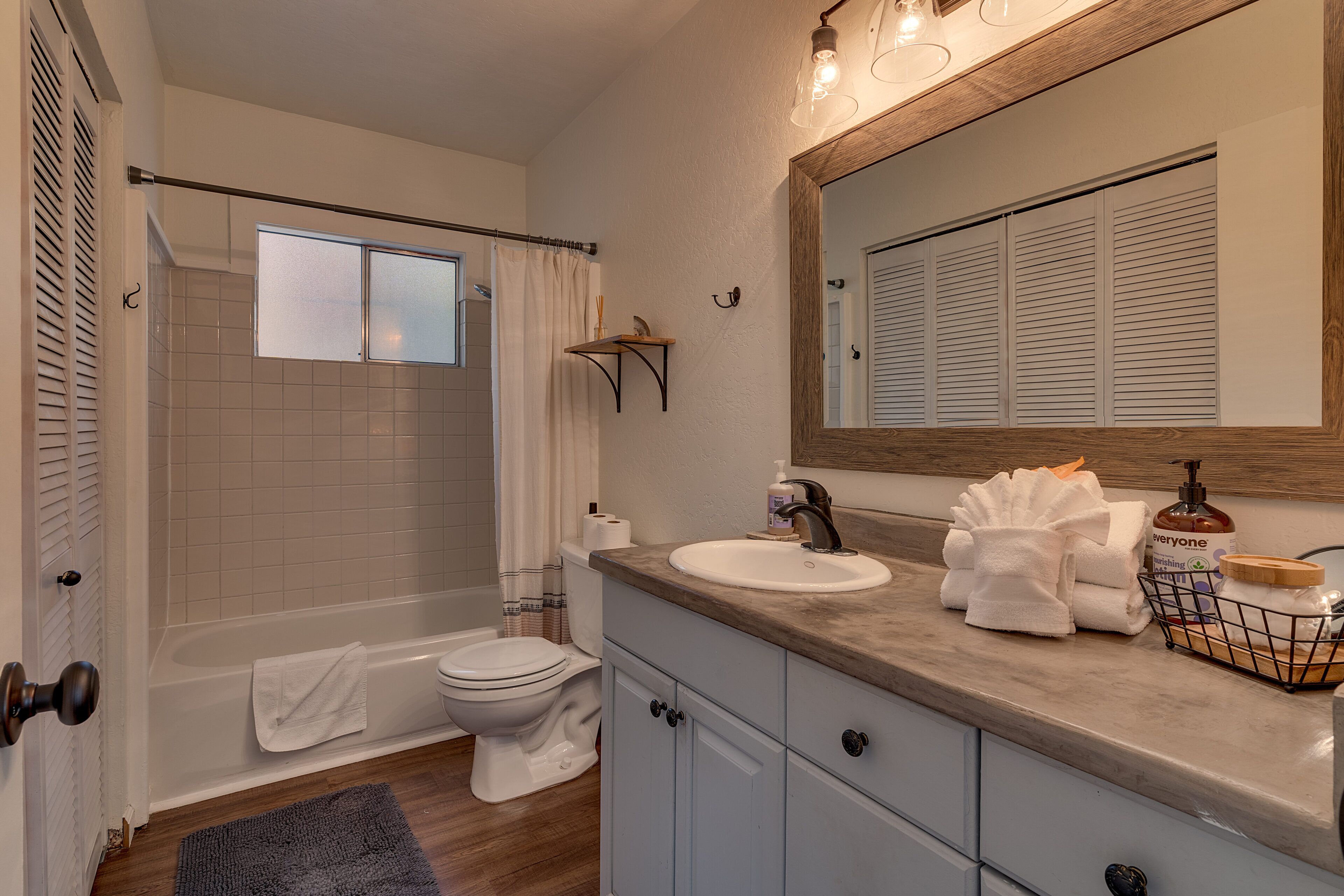 Ein Badezimmer mit Badewanne, Toilette, Waschbecken und Spiegel.