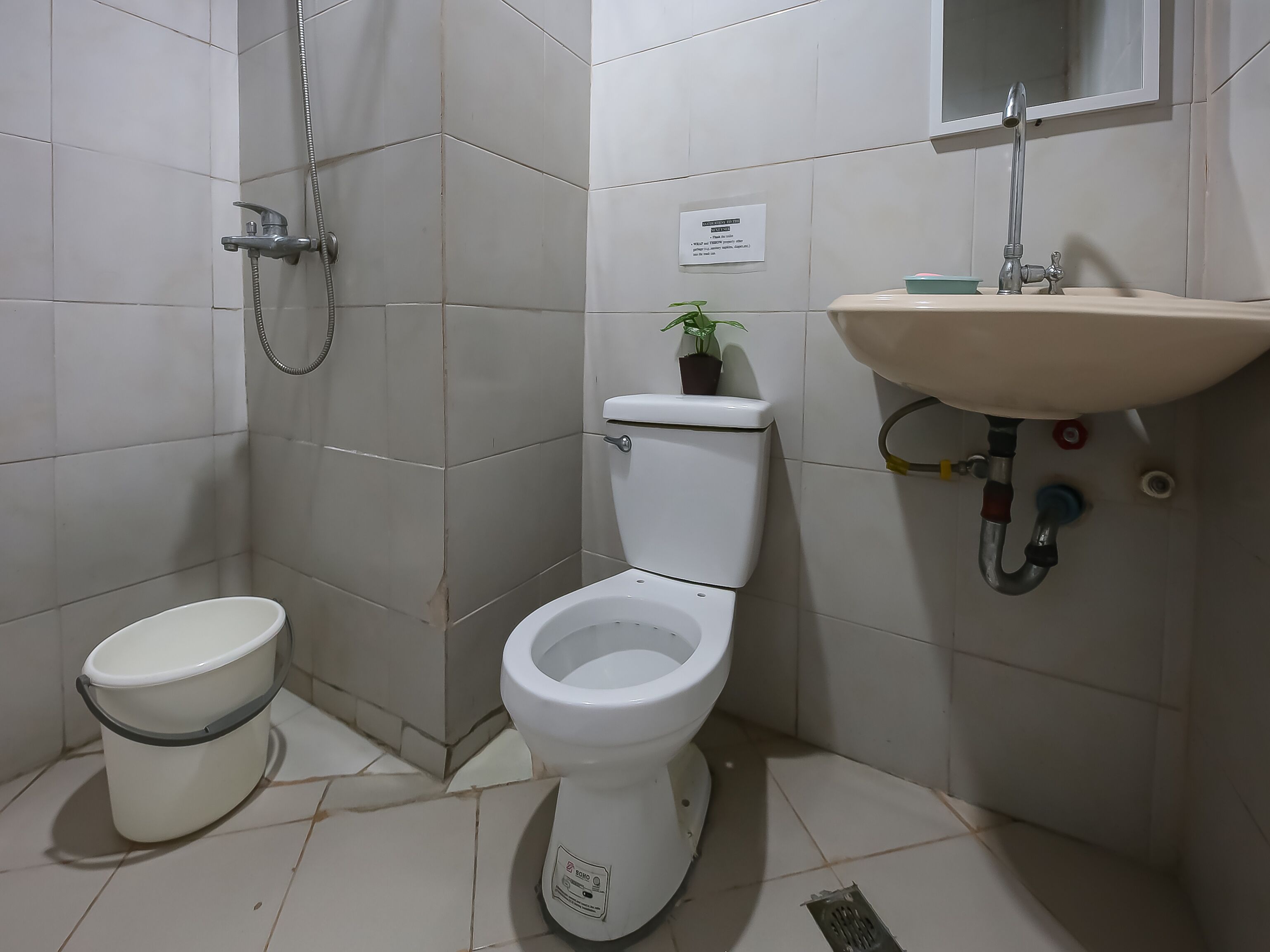 A bathroom with a toilet, a shower, and a sink.