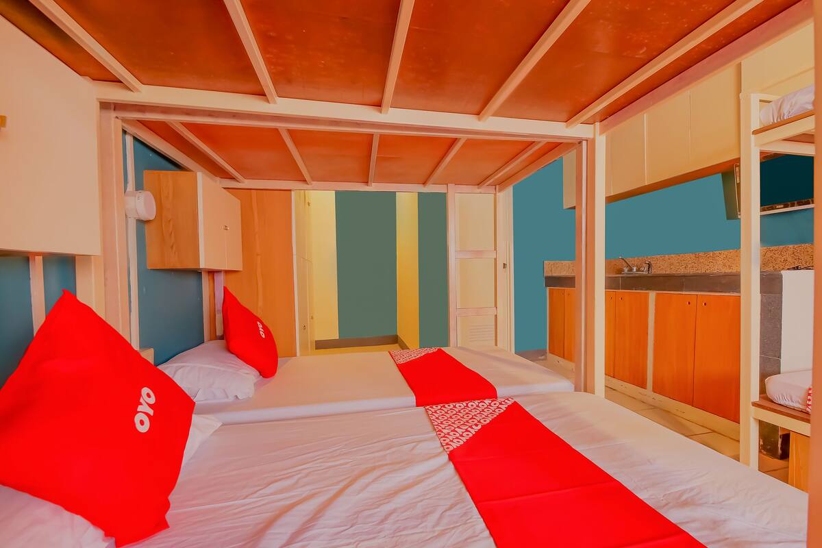 A hotel room with a bunk bed, a desk, and a wardrobe.