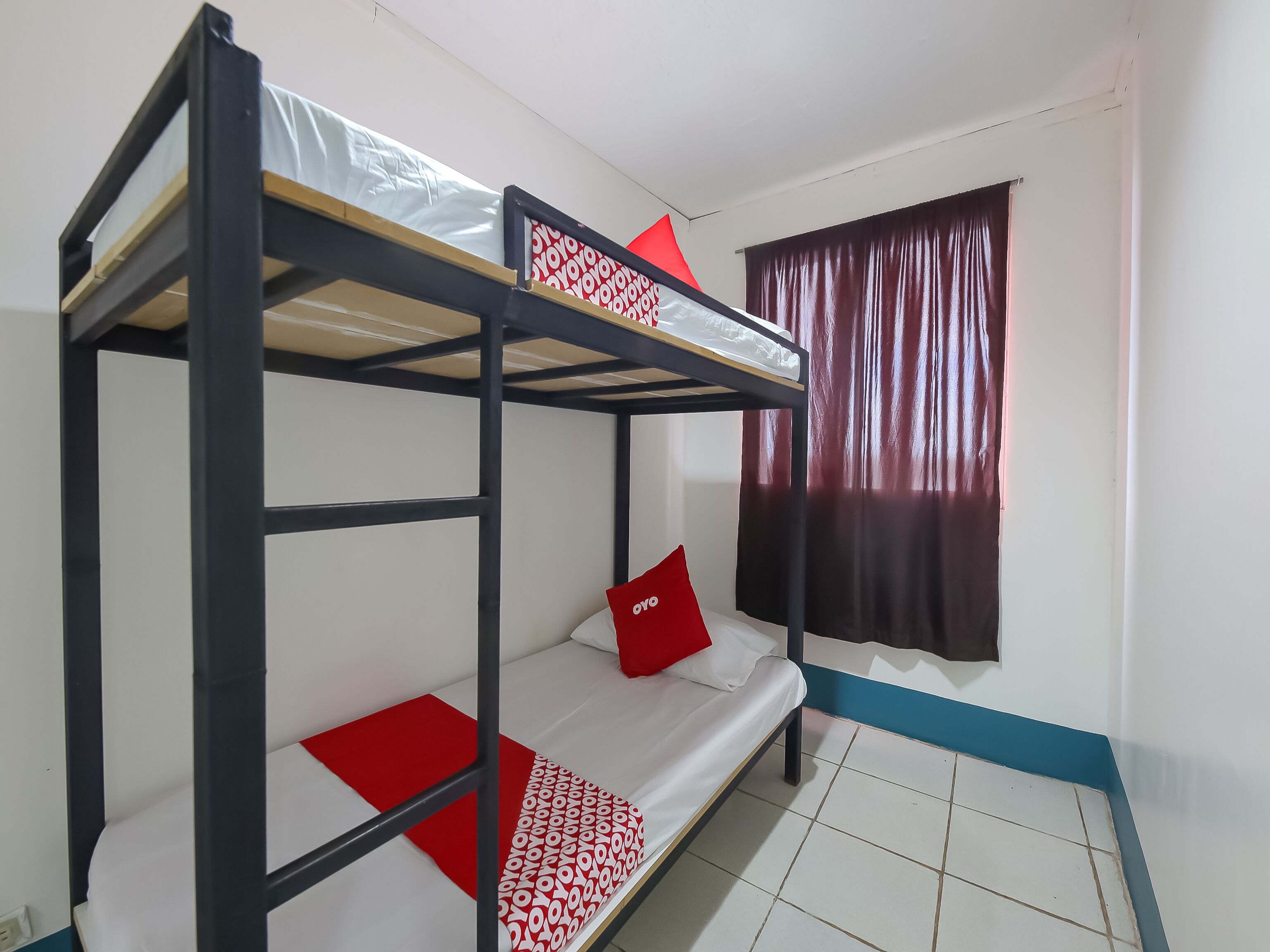 A bunk bed room with a window and curtains.
