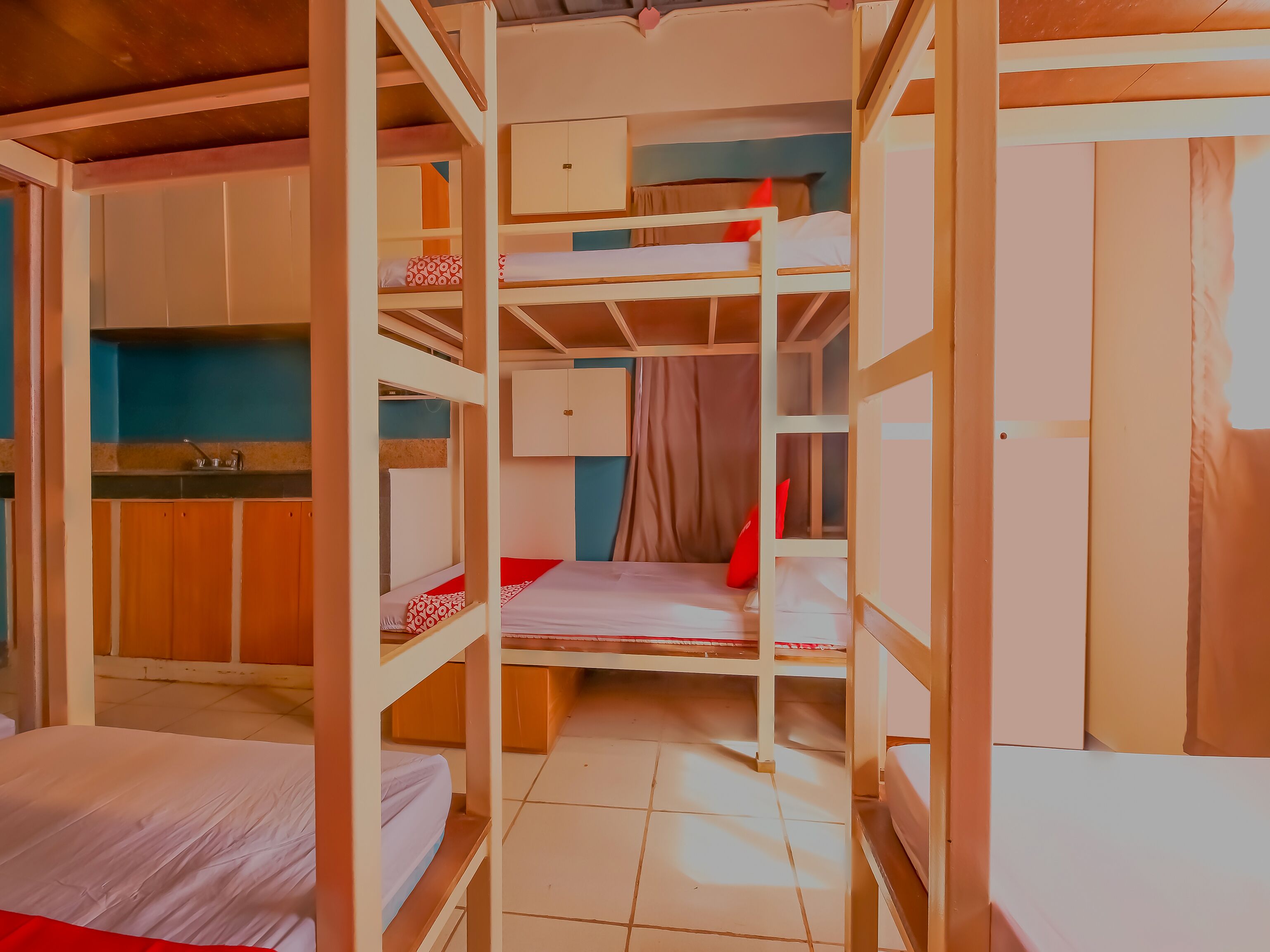 Habitación con literas y una zona de cocina, que incluye armarios y un lavabo.