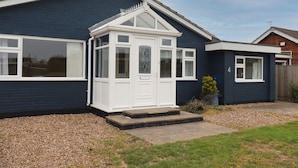 A residential house with a bay window, a small porch, and a number '4' on the side.
