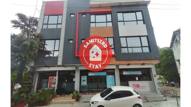 A building with a large red sign reading "SANITIZED STAY". - Capital O 811 Tri A's Building (Olongapo)