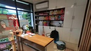 A modern kitchen with a wooden countertop, a sink, and a variety of kitchen items. There is a window with a view of greenery outside. - Capital O 811 Tri A's Building (Olongapo)
