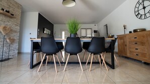 A modern kitchen with a central island, black chairs, a potted plant, and a wooden cabinet. - Villa "La Romarine" for 6 people in a quiet location with magnificent views  (Salernes)
