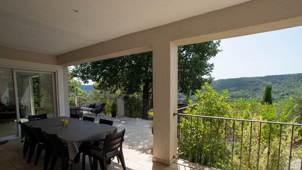 An outdoor patio with a table and chairs, a glass door leading inside, and a view of a lush landscape. - Villa "La Romarine" for 6 people in a quiet location with magnificent views  (Salernes)