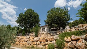 A stone wall with a pathway leading to a building with a white facade and a red-tiled roof. - Villa "La Romarine" for 6 people in a quiet location with magnificent views  (Salernes)