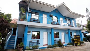 A two-story building with a blue facade, a balcony on the upper floor, and a sign indicating it's a budget hotel with free parking. - OYO 814 Laurien's Budget Hotel (Tagaytay)