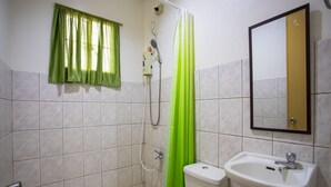 A bathroom with a toilet, sink, shower, and a window with green curtains. - OYO 814 Laurien's Budget Hotel (Tagaytay)