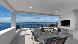 Un balcón con una mesa dispuesta para el desayuno, con vistas a la costa.