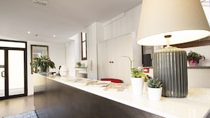Una cocina moderna con una encimera amplia, una lámpara grande y varias plantas en macetas.