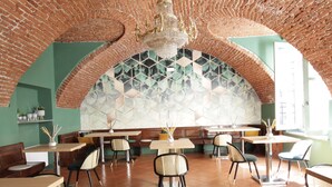 Un restaurante con arcos de ladrillo, suelos de baldosas y mobiliario moderno.