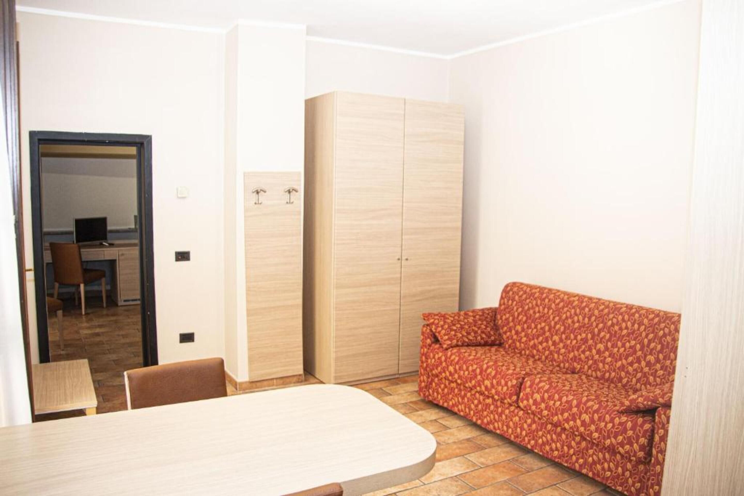 A compact living space with a dining table, a sofa, and a wardrobe.