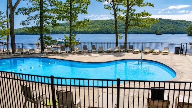 A swimming pool with lounge chairs and a view of a lake. - Scandi Lakefront Stay w/ Free Pool & Club Passes (Lake Harmony)