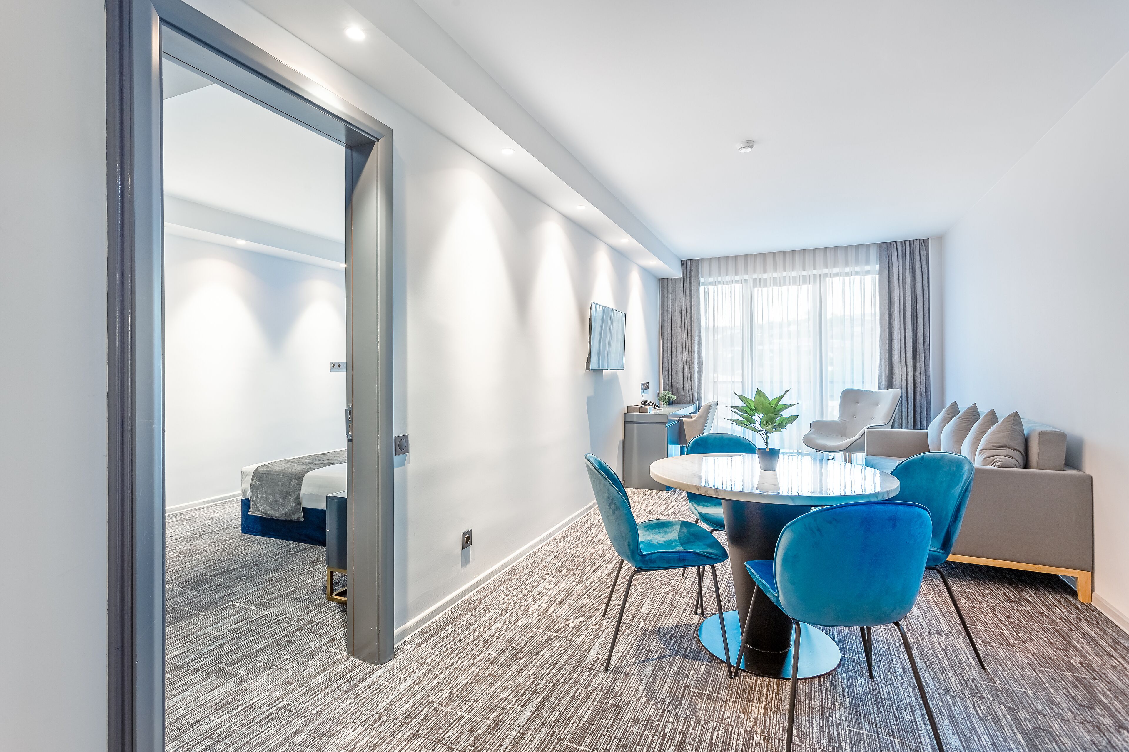 Une chambre d’hôtel moderne avec un coin repas, un canapé et un lit.