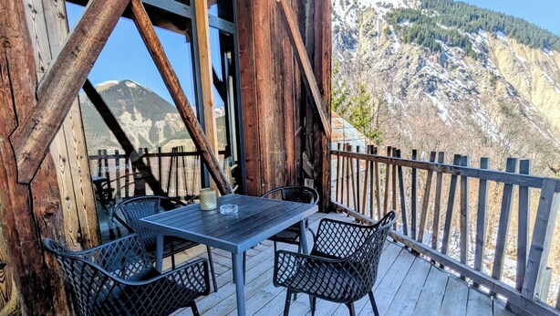 A wooden deck with a table and chairs, overlooking a mountainous landscape. - Grange de Marius - Authentic Savoyard barn (Albiez-Montrond)
