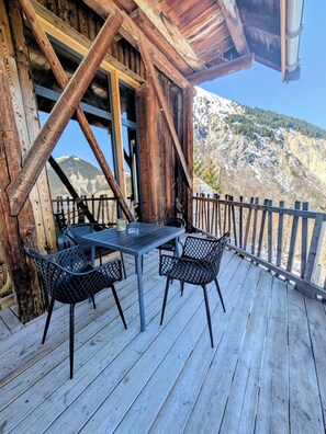 A wooden deck with a table and chairs, overlooking a mountainous landscape. - Grange de Marius - Authentic Savoyard barn (Albiez-Montrond)