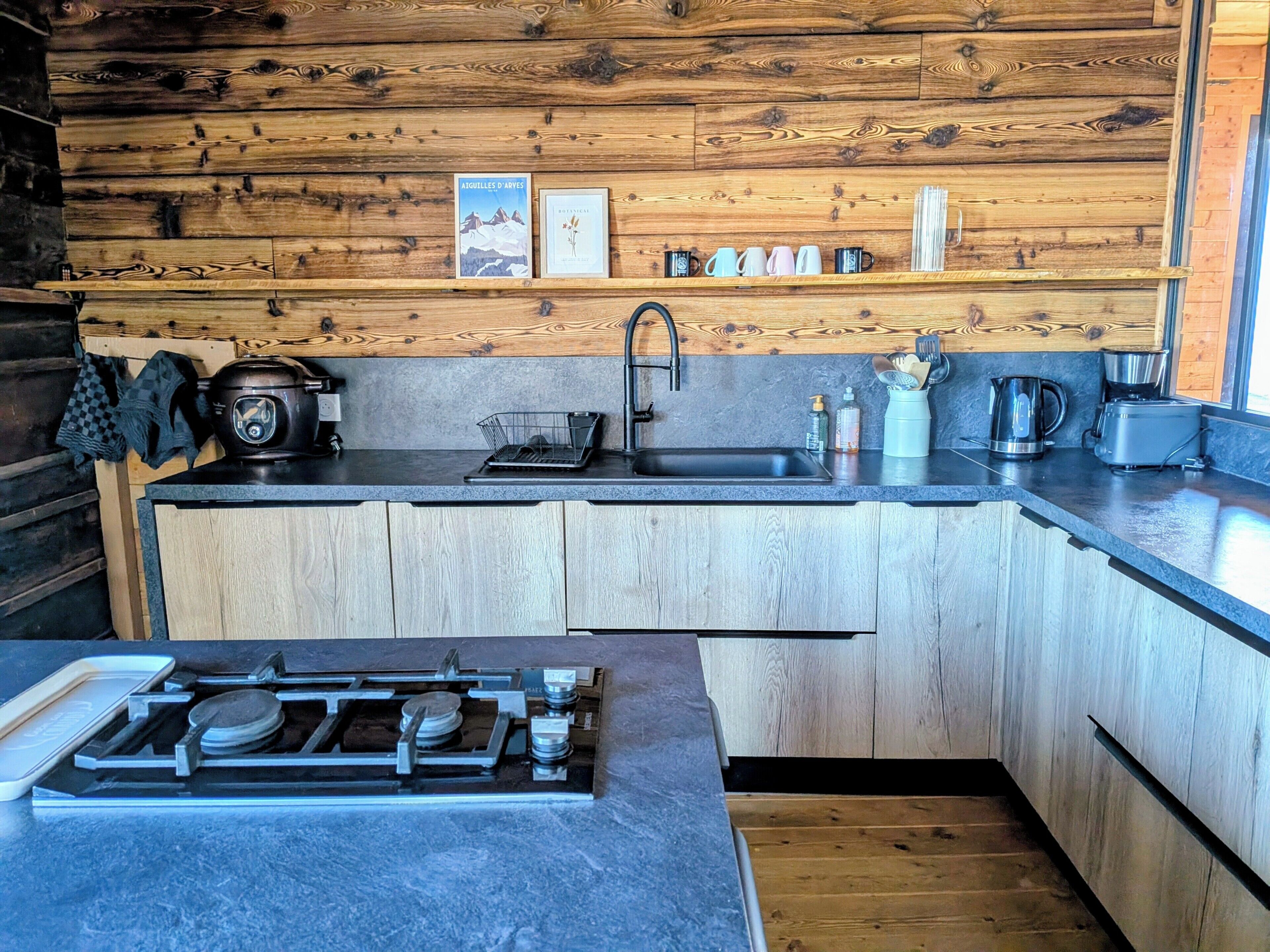 A compact kitchen with a built-in stove, a sink, and wooden cabinetry.