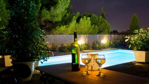Ein Poolbereich mit Tisch, einer Flasche und zwei Gläsern.