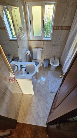Tina con regadera, bidet, toallas 